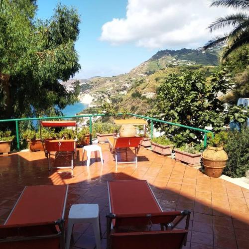 a patio with tables and chairs and a view of the ocean at Hotel Villa al Mare in Ischia