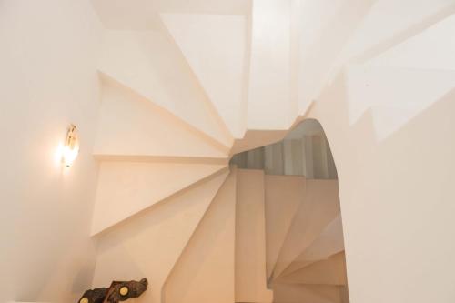 a spiral staircase in a white building with a light bulb at Maria's Traditional Villa in Asklipiḯon