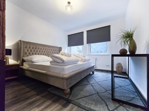 a bedroom with a large bed and two windows at Alpha Apartments in Essen