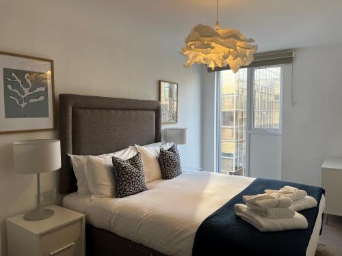 a bedroom with a large bed with towels on it at Southampton City Apartments by Charles Hope in Southampton