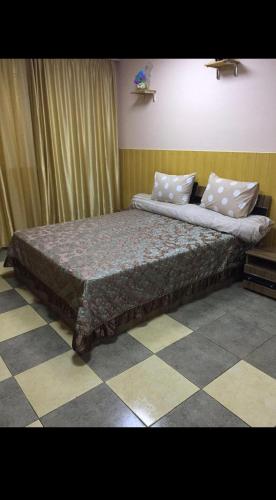 a large bed in a bedroom with a checkered floor at Relax House Downtown !!! in Bălţi