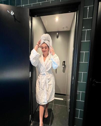 a woman standing in a bathroom with a towel on her head at Durty Nelly's Inn in Amsterdam