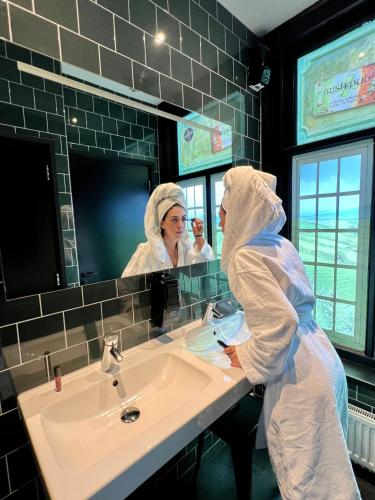 a woman in a bathroom in front of a sink at Durty Nelly's Inn in Amsterdam