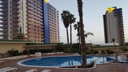 a swimming pool in front of two tall buildings at Club Paraiso 1306 in Playa Paraiso