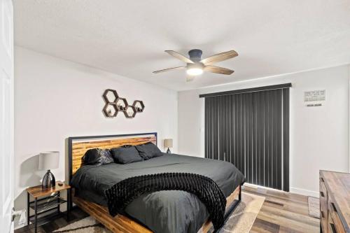 um quarto com uma cama e uma ventoinha de tecto em Prairie South Charmer em Grande Prairie