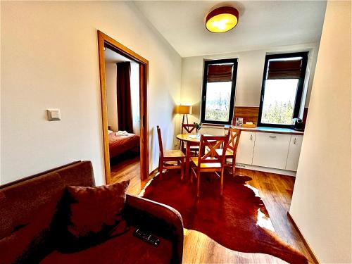 a living room with a table and a dining room at Paseky Apartments Resort in Nové Město na Moravě