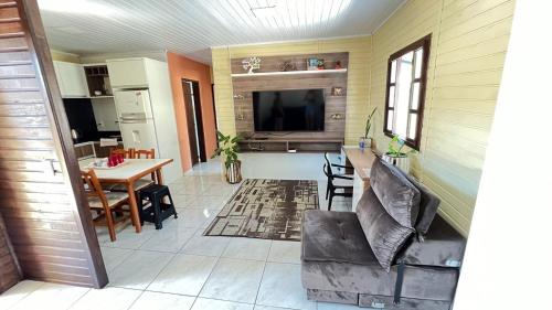 uma cozinha e sala de estar com mesa e cadeiras em La Casa de Gramado em Gramado