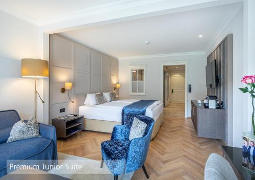 a hotel room with a bed and a couch at Lenkerhof gourmet spa resort - Relais & Châteaux in Lenk