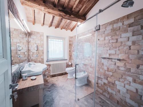 uma casa de banho com uma cabina de duche em vidro e um WC. em Villa Dorotea - Homelike Villas em Porano