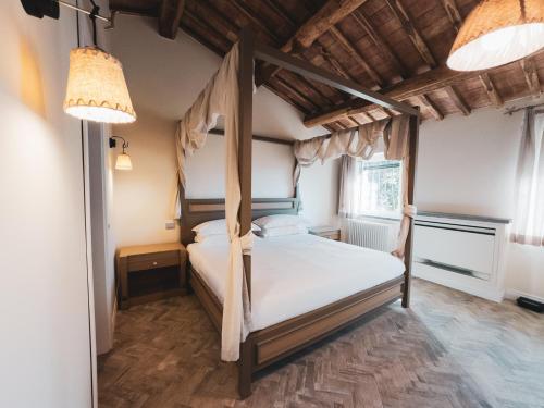 a bedroom with a canopy bed and a window at Villa Dorotea - Homelike Villas in Porano