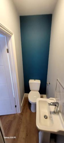 a bathroom with a white toilet and a sink at Nice and Pleasant in Thornton Heath