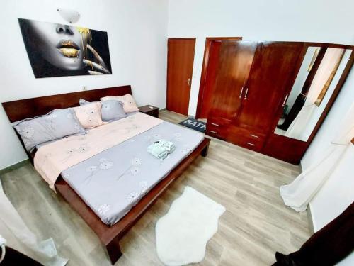 a bedroom with a large bed with pink sheets at Timba chic-villa 1 in Cotonou
