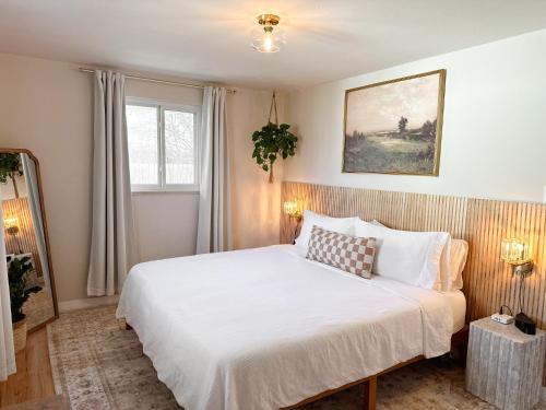 - une chambre avec un grand lit blanc dans l'établissement Mile High Organic Cottage, à Arvada