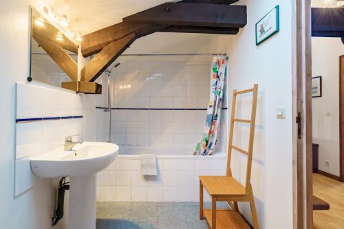 a bathroom with a sink and a bath tub at The Coach House - Avec piscine partagée in Osserain-Rivareyte