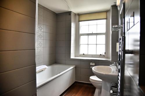 łazienka z wanną, umywalką i toaletą w obiekcie The Castle Hotel Wetherspoon w mieście Ruthin