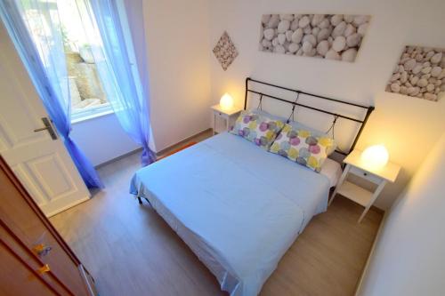 a small bedroom with a bed and a window at Apartment &Scaron;ulić in Dubrovnik