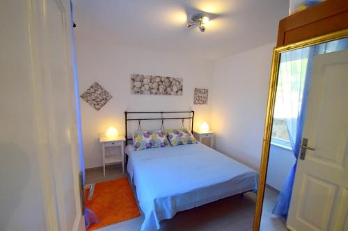 a small bedroom with a bed and a mirror at Apartment &Scaron;ulić in Dubrovnik