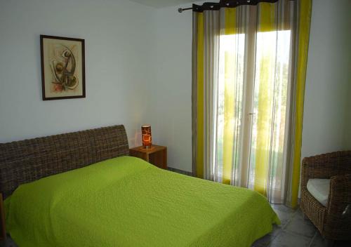 Un dormitorio con una cama verde y una ventana en Villa Patio avec piscine Vallon Pont d'Arc Ardèche, en Sampzon