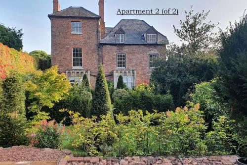 an old brick house with a garden in front of it at Clairville : Georgian Suite - Central Ross-on-Wye in Ross on Wye