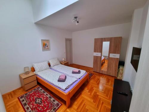 1 dormitorio con 1 cama y suelo de madera en Duplex Frida Zlatibor, en Zlatibor