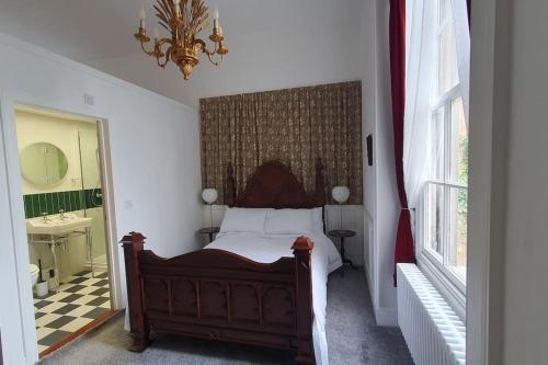 a bedroom with a bed and a sink and a mirror at Clairville : Georgian Suite - Central Ross-on-Wye in Ross on Wye