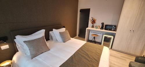 a bedroom with a bed with white sheets and pillows at Den Ommegang in Halle