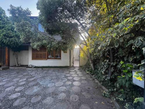 a house with a tree and a stone driveway at Alto Las Condes Apartments in Santiago