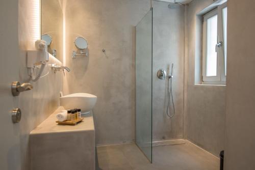 a bathroom with a glass shower and a sink at Beautiful Paros Villa - 1 Bedroom - Villa Rock - Private Jacuzzi and Garden View - Naousa in Livadia