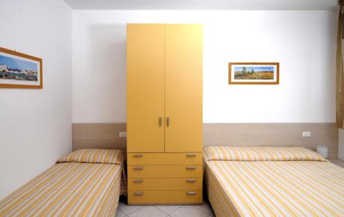 - 2 lits dans une chambre dotée d'une armoire jaune dans l'établissement Family comfort in Bibione - Beahost, à Bibione