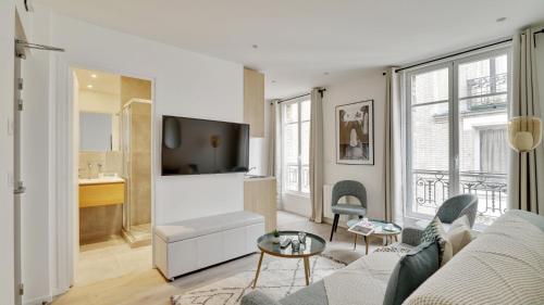 uma sala de estar com um sofá e uma televisão em 158 Suite Jeremy - Superb apartment in Paris em Paris