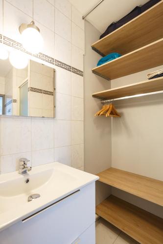 une salle de bain avec un lavabo et un miroir dans l'établissement Appartement Cosy Près de Paris avec vue sur la Tour Eiffel - Parking & Wifi, à Argenteuil