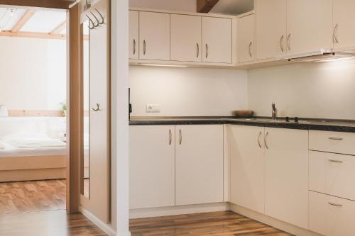 a kitchen with white cabinets and a bed at Ansitz Rynnhof in Termeno