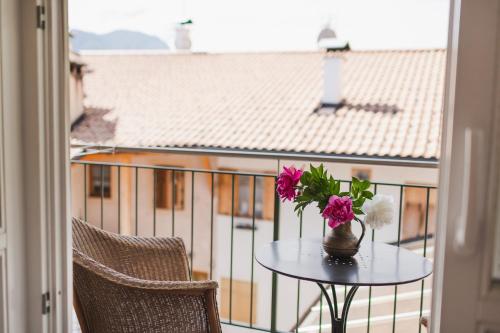 a table with a vase of flowers on a balcony at Ansitz Rynnhof in Termeno