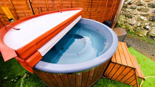 uma grande piscina de água num balde de madeira em Cader Mountain View Cottage with Hot Tub in Snowdonia em Dolgellau