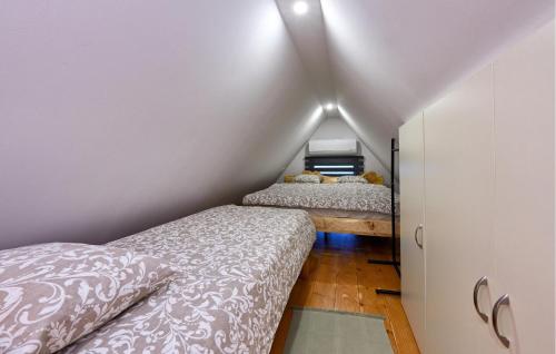 a attic bedroom with two beds in a room at Cozy Home In Vukovoj With Wi-Fi in Vukovoj
