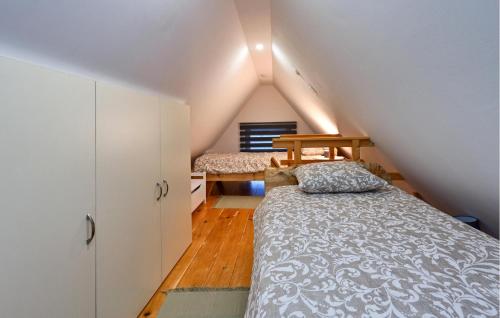 um quarto no sótão com 2 camas e armários brancos em Cozy Home In Vukovoj With Wi-fi 