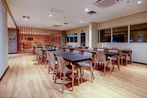 une salle de conférence avec des tables et des chaises en bois dans l'établissement Transamerica Fit Sorriso, à Sorriso