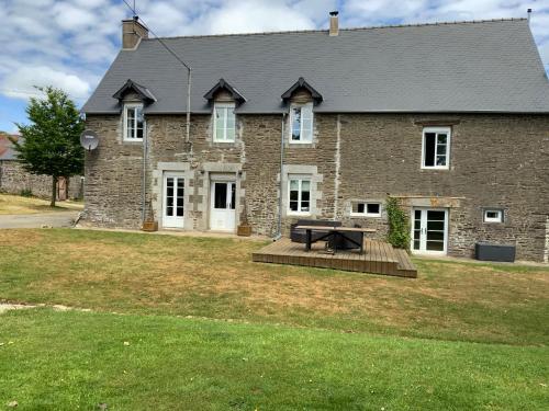 a large brick house with a picnic table in the yard at Welcoming and peaceful bed and breakfast in Fougerolles-du-Plessis