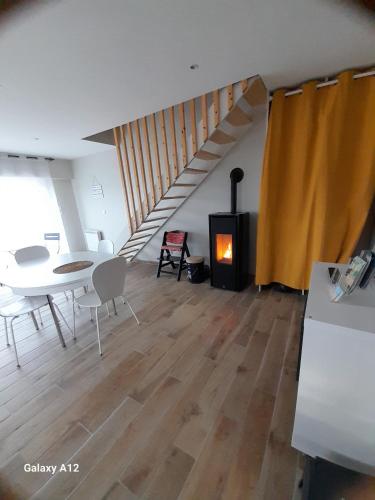 sala de estar con mesa y estufa de leña en maison bord de mer en Mesquer