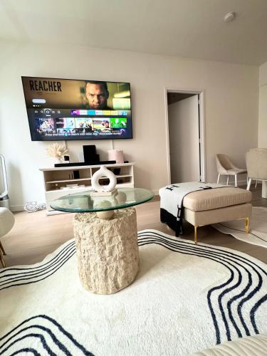 sala de estar con mesa y TV en Exquisite Urban Oasis: Luxury 1 Bedroom Retreat in Downtown Manhattan, en Nueva York