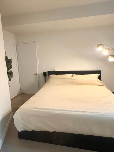 a bedroom with a large bed with white sheets at Exquisite Urban Oasis: Luxury 1 Bedroom Retreat in Downtown Manhattan in New York