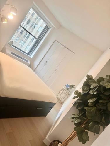 1 dormitorio con 1 cama y una maceta en Exquisite Urban Oasis: Luxury 1 Bedroom Retreat in Downtown Manhattan, en Nueva York