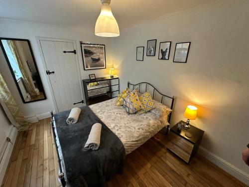 1 dormitorio con 1 cama y 1 mesa con lámpara en Seafront Apartment with Garden en Brighton & Hove