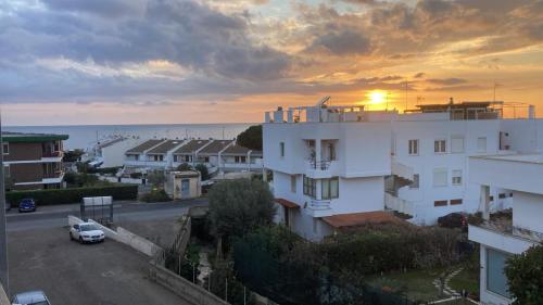 a sunset over a white building and the ocean at APPARTAMENTO con TERRAZZA SUL MARE in Santa Marinella