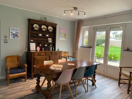 ein Esszimmer mit einem Holztisch und Stühlen in der Unterkunft Vacances de charme entre mer et campagne - Ty Meur in Pleumeur-Bodou