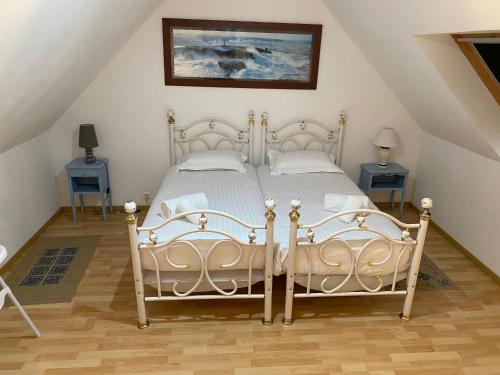 een slaapkamer met 2 witte bedden en 2 tafels bij Vacances de charme entre mer et campagne - Ty Meur in Pleumeur-Bodou