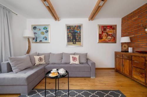 a living room with a couch and a table at Comfortable Apartment Chramcówki in the Centre of Zakopane by Renters in Zakopane