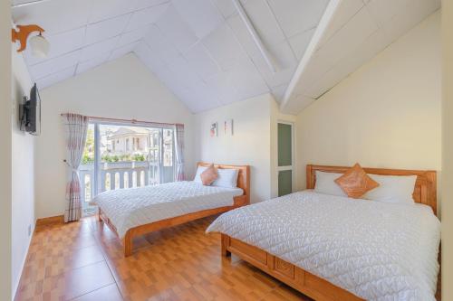 a bedroom with two beds and a window at Mie House Da Lat in Xuan An