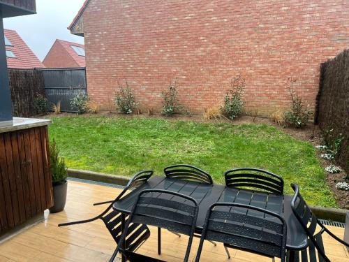 einen schwarzen Tisch und Stühle auf einer Terrasse in der Unterkunft La clef des champs in Gruson