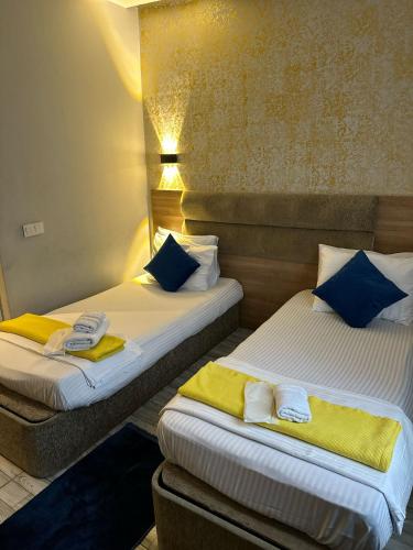 two beds in a hotel room with yellow and blue pillows at Mayata Pera in Istanbul